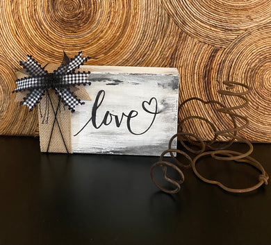 Love Block LOVE BLOCK...this 5 1/2” (h) x 8 1/2” (wide) wood block is painted with Snow White Chalk Style Paint with the love design in Velvet Black Chalkology Paste and ribbon in burlap/black & white small Buffalo Print/black gauze/black cord.  What a cute addition to any Farmhouse Décor.